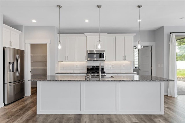 4919 E Grace Ave, Spokane, WA 99217 - kitchen with appliances with stainless steel finishes, decorative backsplash, white cabinets, dark stone countertops, and wood finished floors