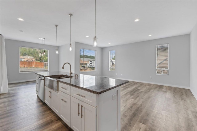 4919 E Grace Ave, Spokane, WA 99217 - kitchen featuring dark stone countertops, white cabinets, wood finished floors, a kitchen island with sink, and recessed lighting