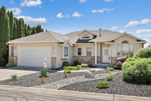8710 E Sugar Pine Ln, Spokane, WA 99217 - view of front of house featuring stone siding, an attached garage, concrete driveway, and a shingled roof