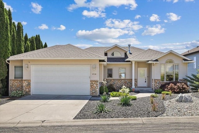 8710 E Sugar Pine Ln, Spokane, WA 99217 - view of front facade featuring stone siding, concrete driveway, a garage, and roof with shingles