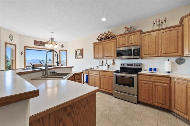8710 E Sugar Pine Ln, Spokane, WA 99217 - kitchen with appliances with stainless steel finishes, light countertops, light tile patterned flooring, a chandelier, and a textured ceiling