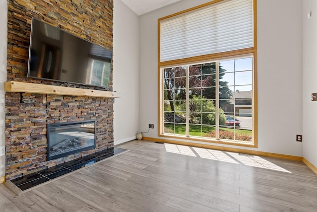 8603 E Columbia Park Dr, Spokane Valley, WA 99212 - unfurnished living room featuring wood finished floors and a stone fireplace