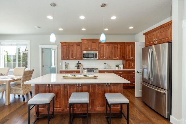 705 W Basalt Ridge Dr, Spokane, WA 99224 - kitchen featuring stainless steel appliances, light countertops, dark wood-style flooring, a kitchen bar, and recessed lighting