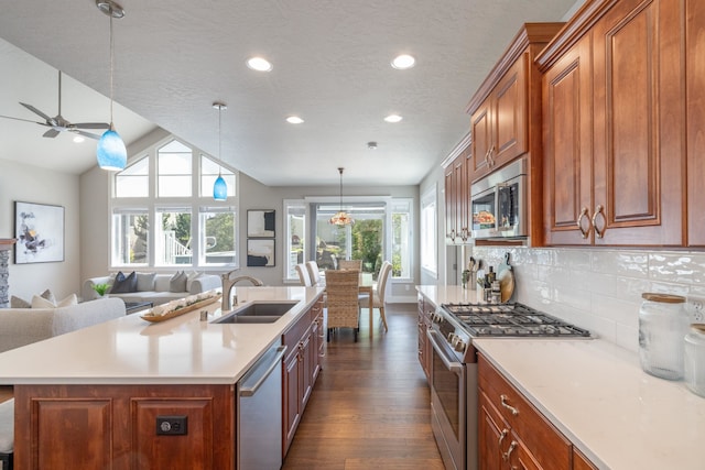 705 W Basalt Ridge Dr, Spokane, WA 99224 - kitchen featuring appliances with stainless steel finishes, open floor plan, dark wood-style flooring, a ceiling fan, and brown cabinets