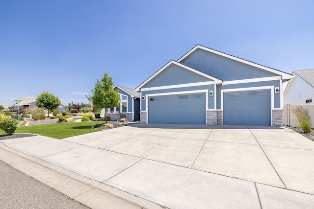 705 W Basalt Ridge Dr, Spokane, WA 99224 - craftsman-style home featuring driveway, a garage, a front lawn, and stone siding
