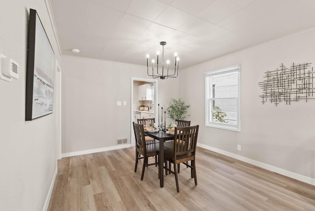 1115 E Everett Ave, Spokane, WA 99207 - dining area featuring a chandelier, crown molding, and light wood-type flooring