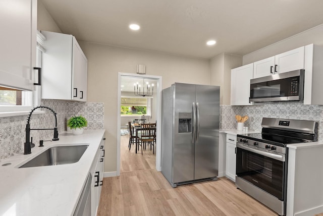 1115 E Everett Ave, Spokane, WA 99207 - kitchen with stainless steel appliances, light wood-style floors, white cabinets, tasteful backsplash, and recessed lighting