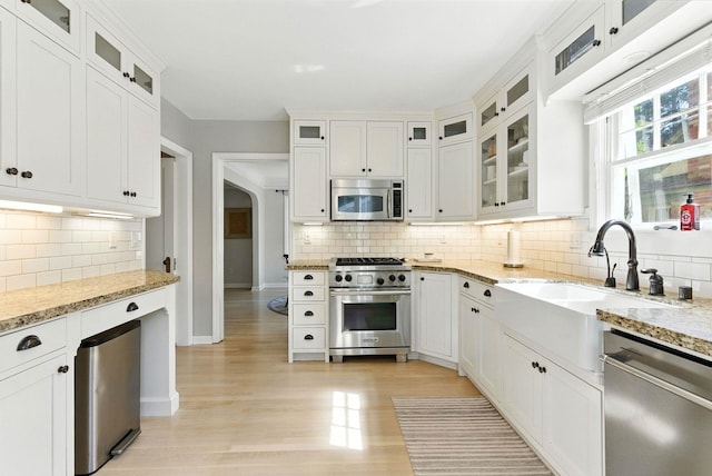 914 E 17th Ave, Spokane, WA 99203 - kitchen featuring appliances with stainless steel finishes, decorative backsplash, light wood-style floors, and white cabinetry
