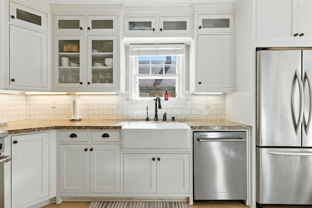 914 E 17th Ave, Spokane, WA 99203 - kitchen with appliances with stainless steel finishes, tasteful backsplash, white cabinets, light stone counters, and glass insert cabinets