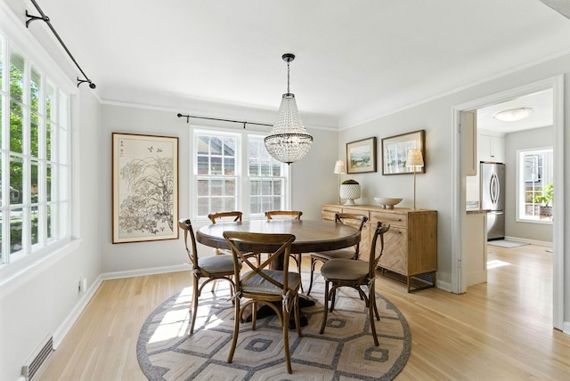 914 E 17th Ave, Spokane, WA 99203 - dining area featuring crown molding, light wood finished floors, healthy amount of natural light, and a chandelier