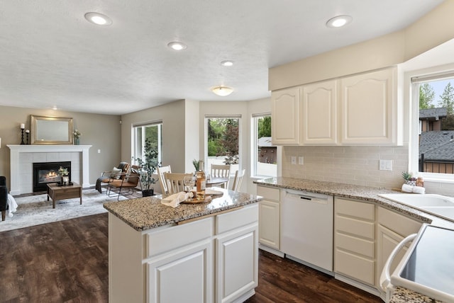 14 W Elcliff Ave, Spokane, WA 99218 - kitchen featuring dishwasher, plenty of natural light, a tile fireplace, dark wood finished floors, and recessed lighting