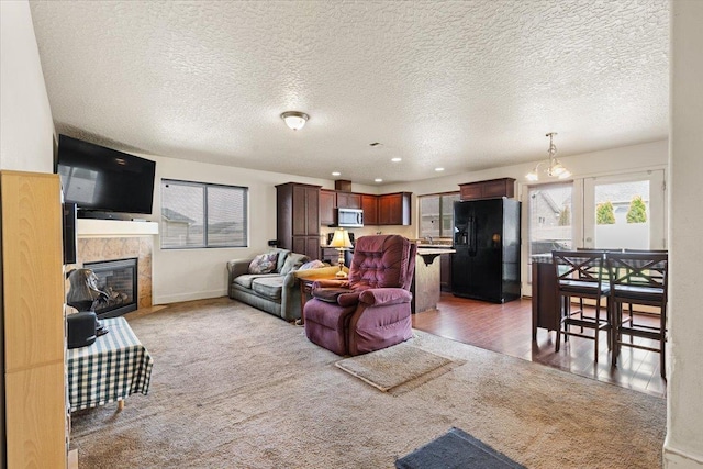 7619 S Camille Ct, Cheney, WA 99004 - living room featuring light colored carpet, a tiled fireplace, and a textured ceiling