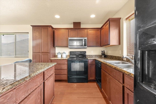 7619 S Camille Ct, Cheney, WA 99004 - kitchen featuring black appliances, light wood-type flooring, brown cabinets, and a textured ceiling