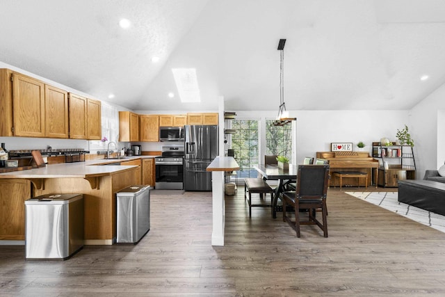 5706 W Excell Ave, Spokane, WA 99208 - kitchen featuring stainless steel appliances, a peninsula, light countertops, light wood finished floors, and recessed lighting