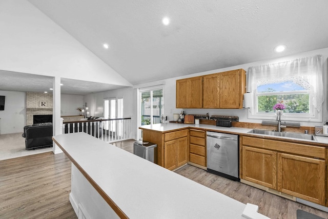 5706 W Excell Ave, Spokane, WA 99208 - kitchen featuring dishwasher, light wood-style flooring, recessed lighting, a brick fireplace, and light countertops