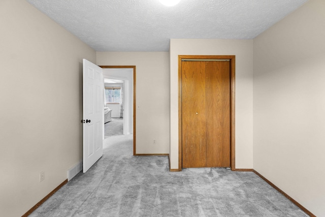5706 W Excell Ave, Spokane, WA 99208 - unfurnished bedroom featuring carpet flooring, a textured ceiling, and a closet