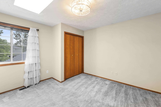 5706 W Excell Ave, Spokane, WA 99208 - unfurnished bedroom with a closet, carpet flooring, a textured ceiling, and a skylight