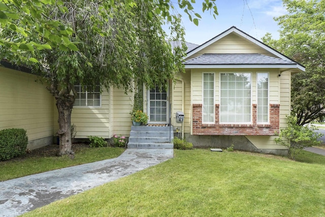 5706 W Excell Ave, Spokane, WA 99208 - view of front facade featuring a front yard, brick siding, and roof with shingles