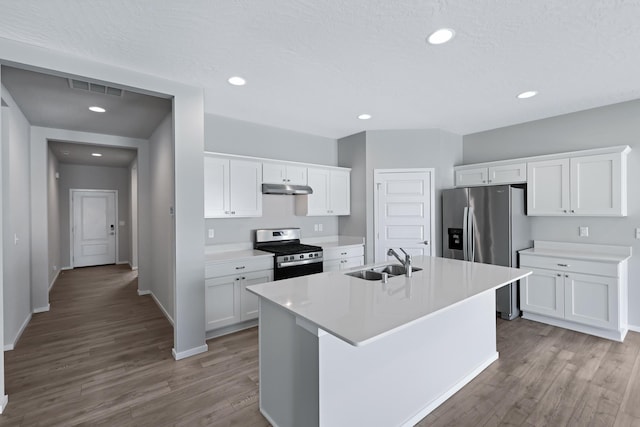8410 W Sugar Ct, Cheney, WA 99004 - kitchen featuring stainless steel appliances, wood finished floors, light countertops, a center island with sink, and white cabinetry