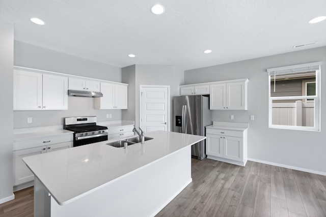 8410 W Sugar Ct, Cheney, WA 99004 - kitchen featuring stainless steel appliances, under cabinet range hood, light wood-style flooring, a kitchen island with sink, and light countertops