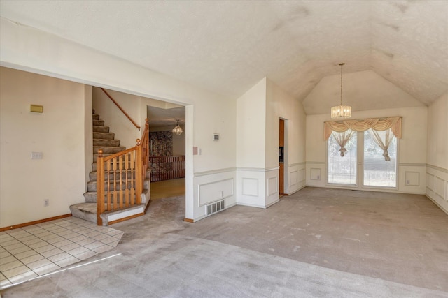 6919 N Pine Rock Pl, Spokane, WA 99208 - carpeted spare room with a chandelier, a decorative wall, wainscoting, stairs, and vaulted ceiling