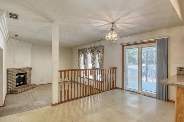 6919 N Pine Rock Pl, Spokane, WA 99208 - unfurnished living room with tile patterned floors, a chandelier, and a fireplace