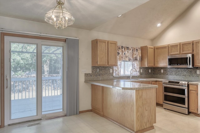 6919 N Pine Rock Pl, Spokane, WA 99208 - kitchen with appliances with stainless steel finishes, decorative backsplash, light countertops, a peninsula, and a chandelier