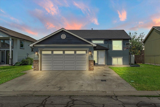 17609 E 2nd Ln, Spokane Valley, WA 99016 - view of front of property with concrete driveway, an attached garage, a yard, and stone siding