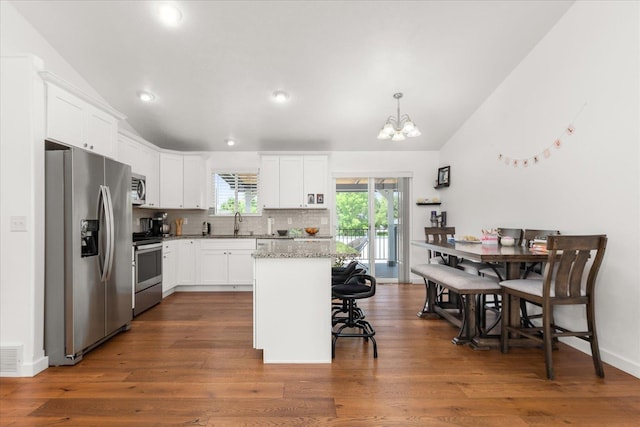 17609 E 2nd Ln, Spokane Valley, WA 99016 - kitchen with stainless steel appliances, vaulted ceiling, a chandelier, a kitchen breakfast bar, and white cabinetry