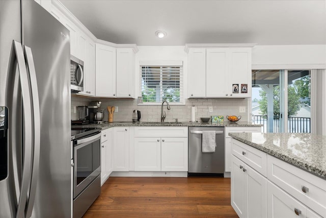 17609 E 2nd Ln, Spokane Valley, WA 99016 - kitchen featuring stainless steel appliances, backsplash, dark wood finished floors, white cabinetry, and light stone counters