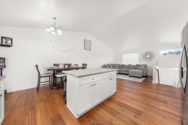 17609 E 2nd Ln, Spokane Valley, WA 99016 - kitchen with a chandelier, vaulted ceiling, light wood-style floors, white cabinets, and decorative light fixtures