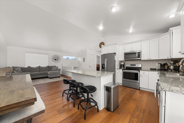 17609 E 2nd Ln, Spokane Valley, WA 99016 - kitchen with appliances with stainless steel finishes, vaulted ceiling, open floor plan, dark wood-style floors, and a breakfast bar