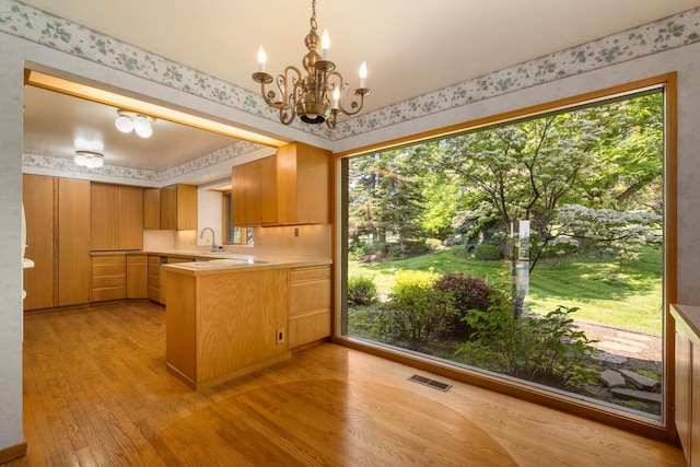 6624 S Ben Burr Rd, Spokane, WA 99223 - kitchen with wallpapered walls, light wood-type flooring, a peninsula, light countertops, and a chandelier