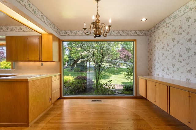 6624 S Ben Burr Rd, Spokane, WA 99223 - unfurnished dining area with wallpapered walls, plenty of natural light, a chandelier, and light wood-type flooring