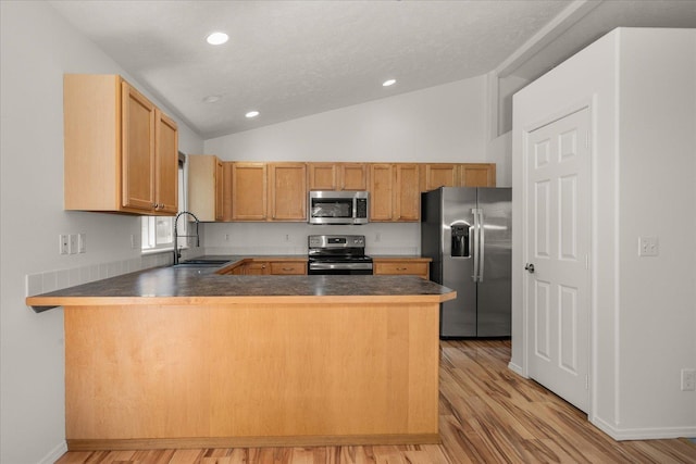 6720 N Royal Ln, Spokane, WA 99208 - kitchen with appliances with stainless steel finishes, a peninsula, lofted ceiling, light wood-type flooring, and recessed lighting