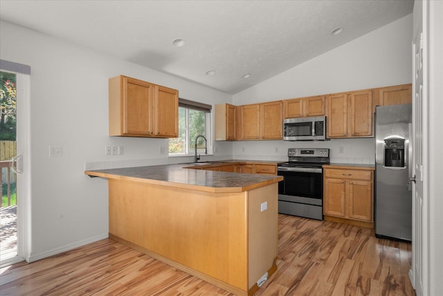 6720 N Royal Ln, Spokane, WA 99208 - kitchen with appliances with stainless steel finishes, a peninsula, light wood finished floors, vaulted ceiling, and recessed lighting