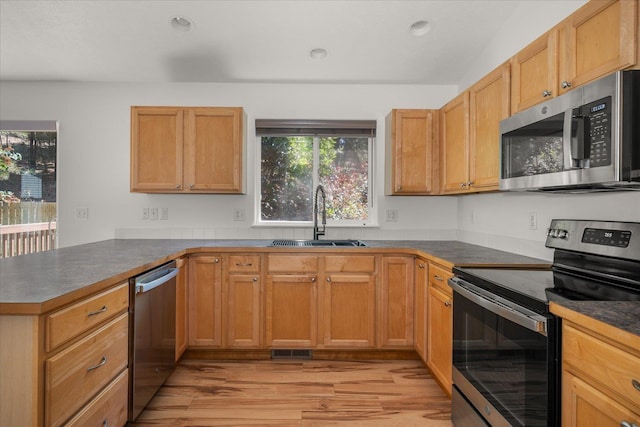 6720 N Royal Ln, Spokane, WA 99208 - kitchen with appliances with stainless steel finishes, light wood-style floors, a peninsula, dark countertops, and recessed lighting