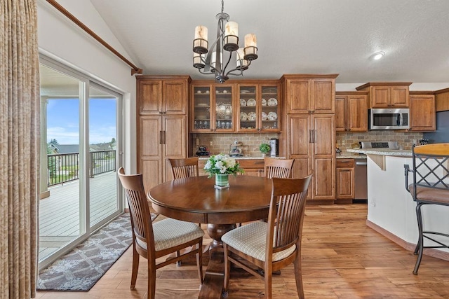 8918 E Clearview Ln, Spokane, WA 99217 - dining space with light wood finished floors, a chandelier, vaulted ceiling, and recessed lighting