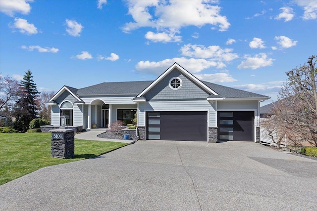 5106 E Glennaire Dr, Spokane, WA 99223 - view of front of house with an attached garage, a front yard, concrete driveway, and stone siding