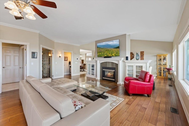 5106 E Glennaire Dr, Spokane, WA 99223 - living room with hardwood / wood-style flooring, ceiling fan, a tiled fireplace, and ornamental molding