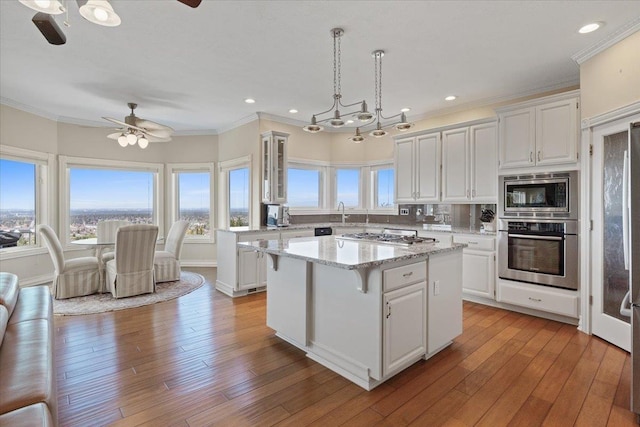 5106 E Glennaire Dr, Spokane, WA 99223 - kitchen with appliances with stainless steel finishes, ceiling fan, white cabinets, ornamental molding, and recessed lighting