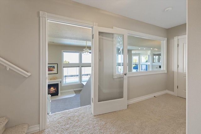 5106 E Glennaire Dr, Spokane, WA 99223 - empty room with carpet floors, a lit fireplace, a ceiling fan, a smoke detector, and stairway
