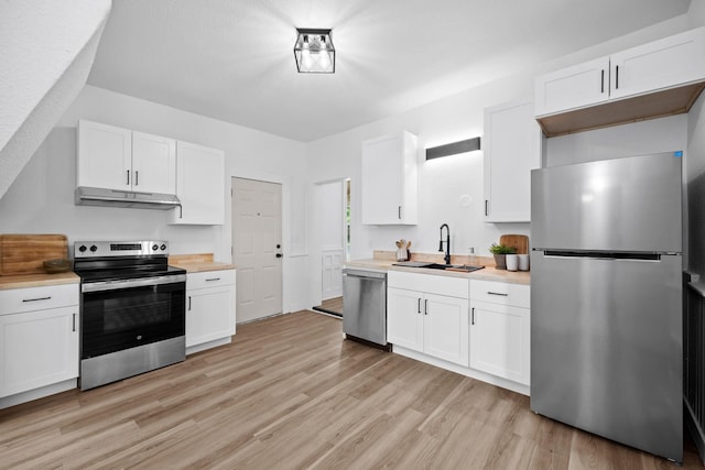 2304 E 6th Ave, Spokane, WA 99202 - kitchen with appliances with stainless steel finishes, light countertops, light wood finished floors, and white cabinetry