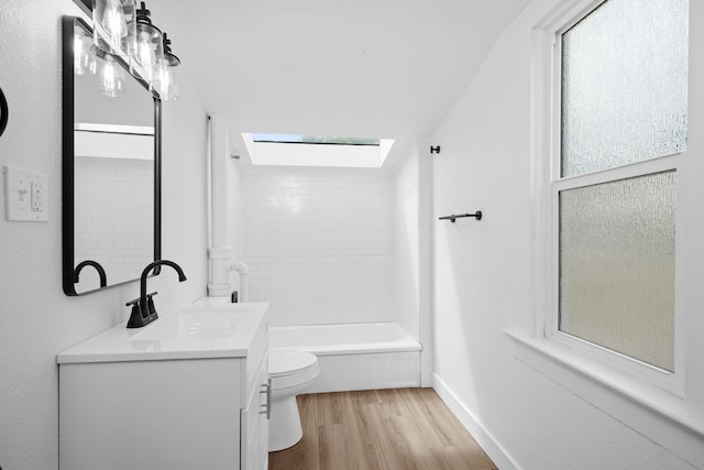 2304 E 6th Ave, Spokane, WA 99202 - bathroom featuring wood finished floors, vanity, a skylight, and washtub / shower combination