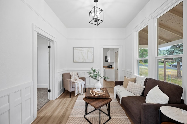 2304 E 6th Ave, Spokane, WA 99202 - sitting room featuring light wood-type flooring, a chandelier, a decorative wall, and wainscoting