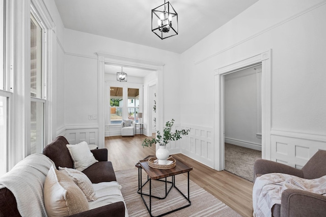 2304 E 6th Ave, Spokane, WA 99202 - living area with a chandelier, wood finished floors, wainscoting, and a decorative wall
