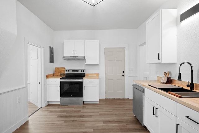 2304 E 6th Ave, Spokane, WA 99202 - kitchen featuring stainless steel appliances, light wood finished floors, under cabinet range hood, and white cabinetry