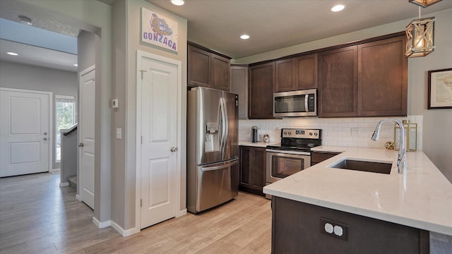 7169 S Parkridge Blvd, Spokane, WA 99224 - kitchen with appliances with stainless steel finishes, dark brown cabinetry, light wood-type flooring, decorative backsplash, and recessed lighting