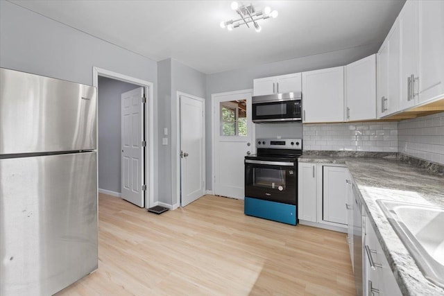 2224 N Lily Rd, Spokane, WA 99212 - kitchen with appliances with stainless steel finishes, tasteful backsplash, white cabinetry, and light wood-style floors