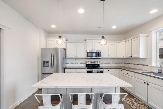 1024 W Staples Rd, Post Falls, ID 83854 - kitchen with stainless steel appliances, dark wood finished floors, a kitchen island, backsplash, and recessed lighting
